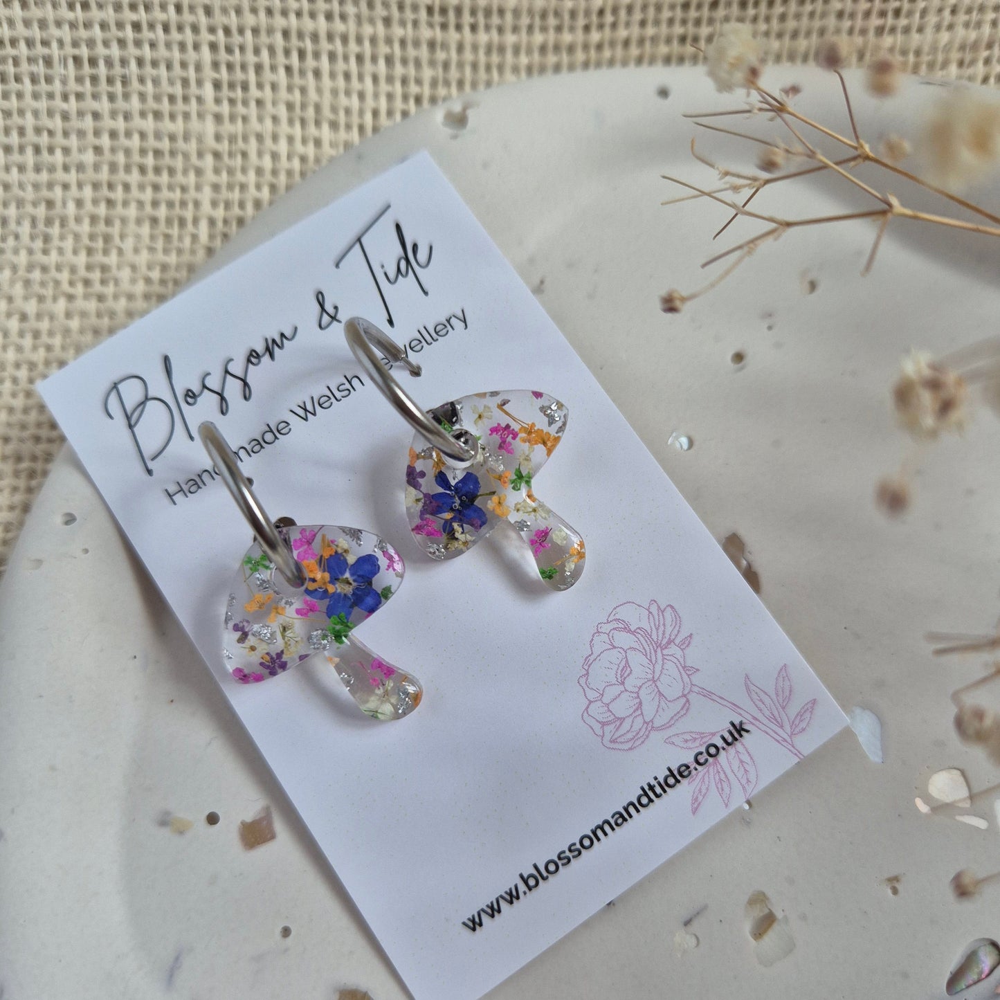 Toadstool hoops with forget-me-nots, pink and orange flowers on stainless steel silver hoops. Shown on Blossom & Tide branded card.