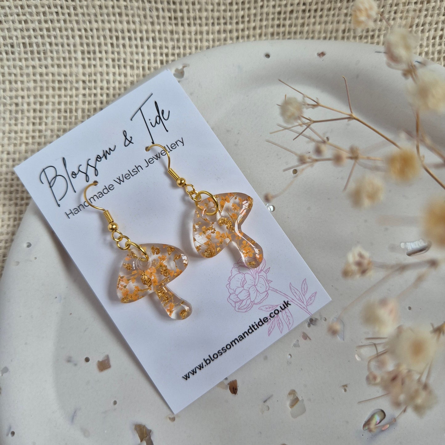 Mushroom earrings with orange flowers on stainless steel gold hooks Shown on Blossom & Tide branded card.