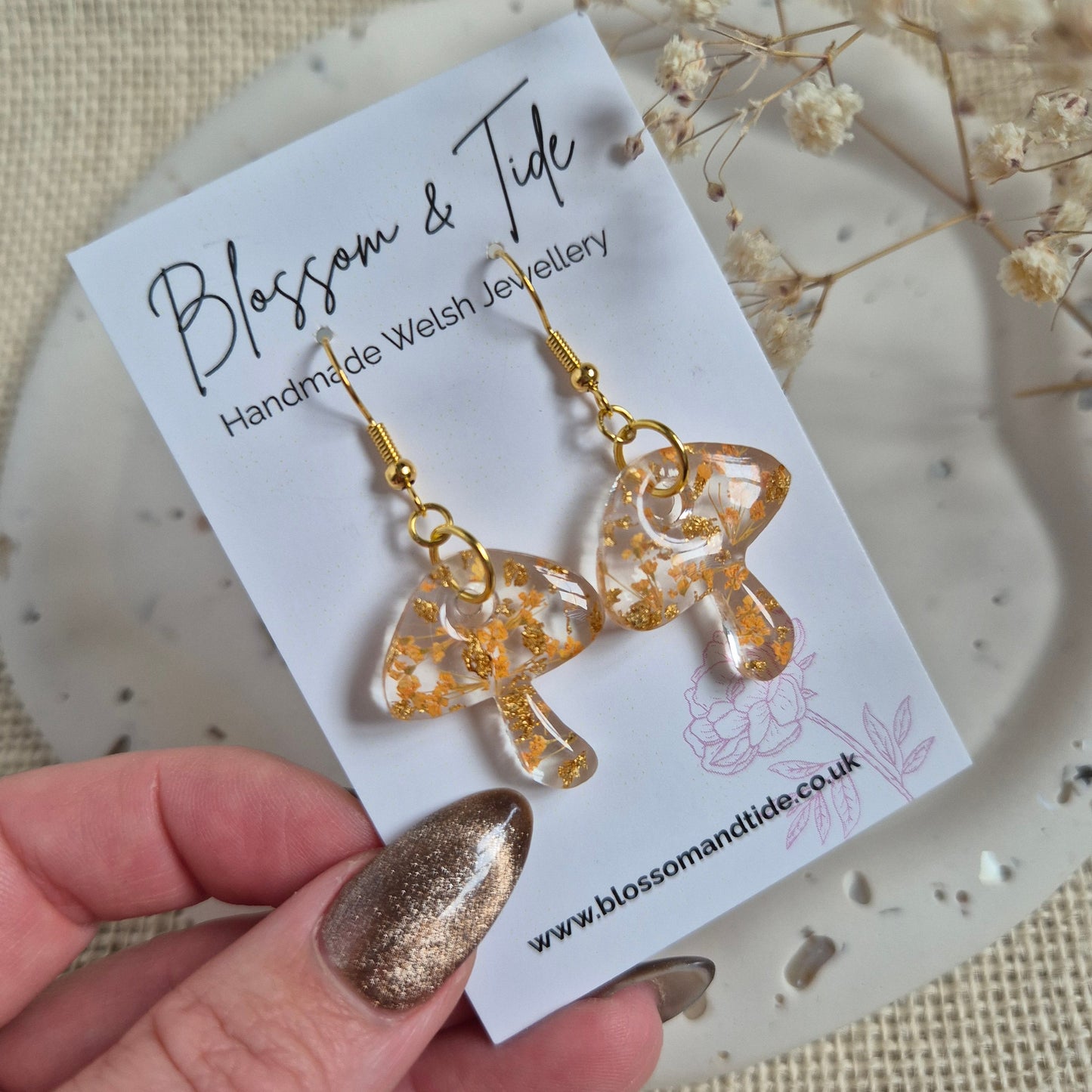 Mushroom earrings with orange flowers on stainless steel gold hooks Shown on Blossom & Tide branded card.
