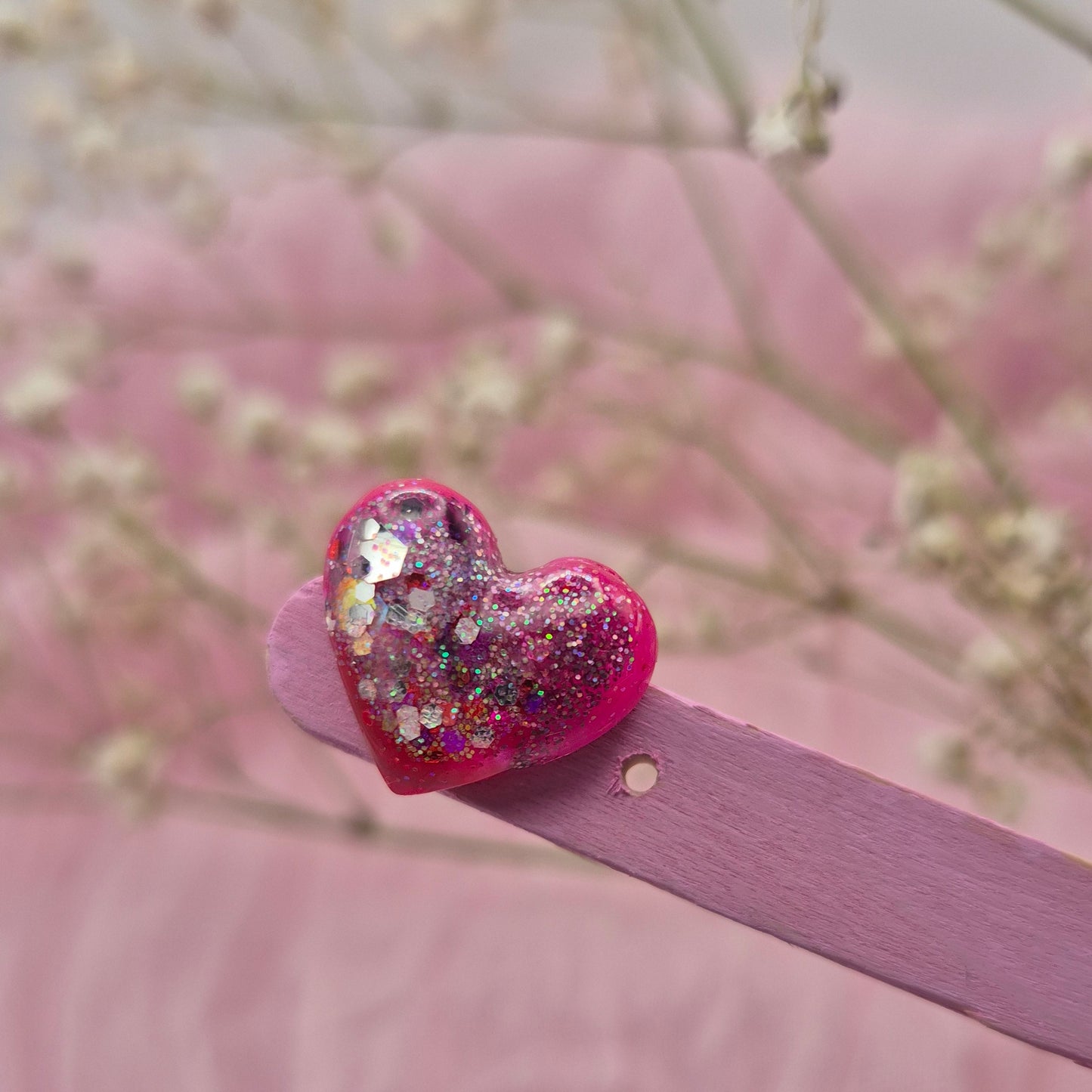 Heart-shaped stud earrings with red, pink, and glitter details.