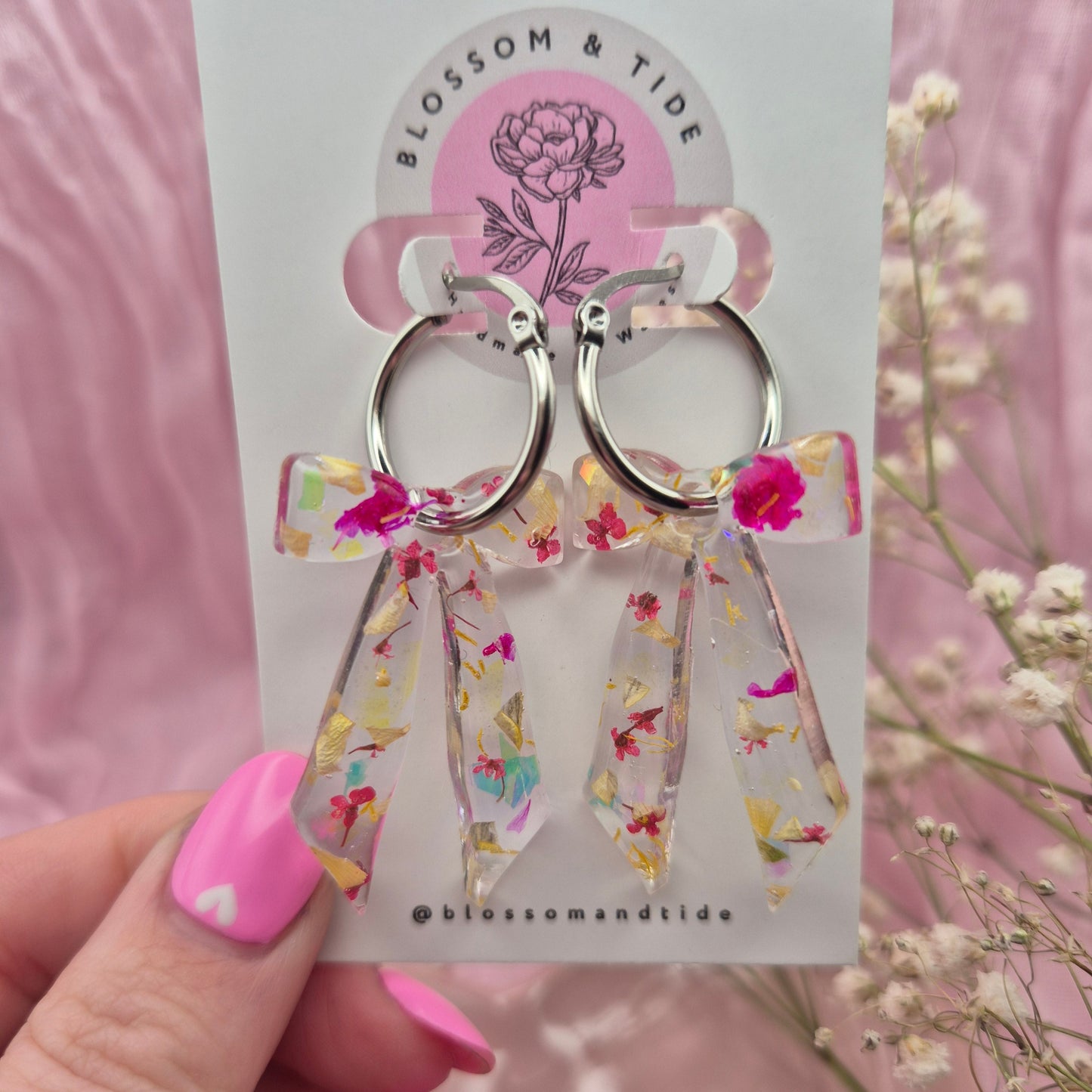 Elegant resin bow earrings with real dried flowers and a touch of shimmer, handmade in Wales