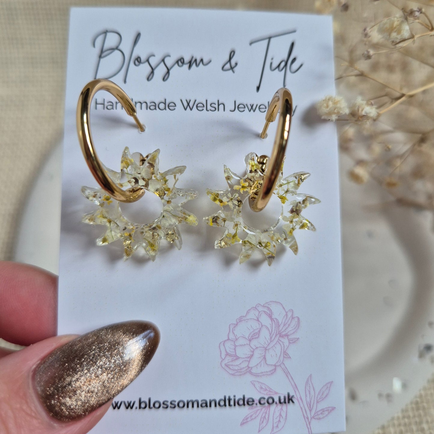 Sun earrings filled with a mix of yellow and white pressed flowers on a stainless steel gold hoop. Presented on a Blossom & Tide branded card.