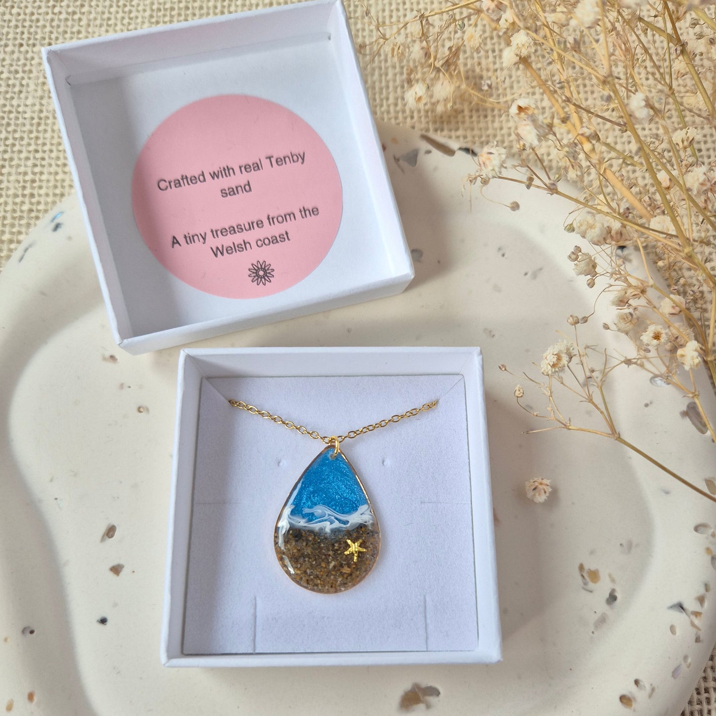 Handmade resin teardrop pendant displayed in branded jewellery box.