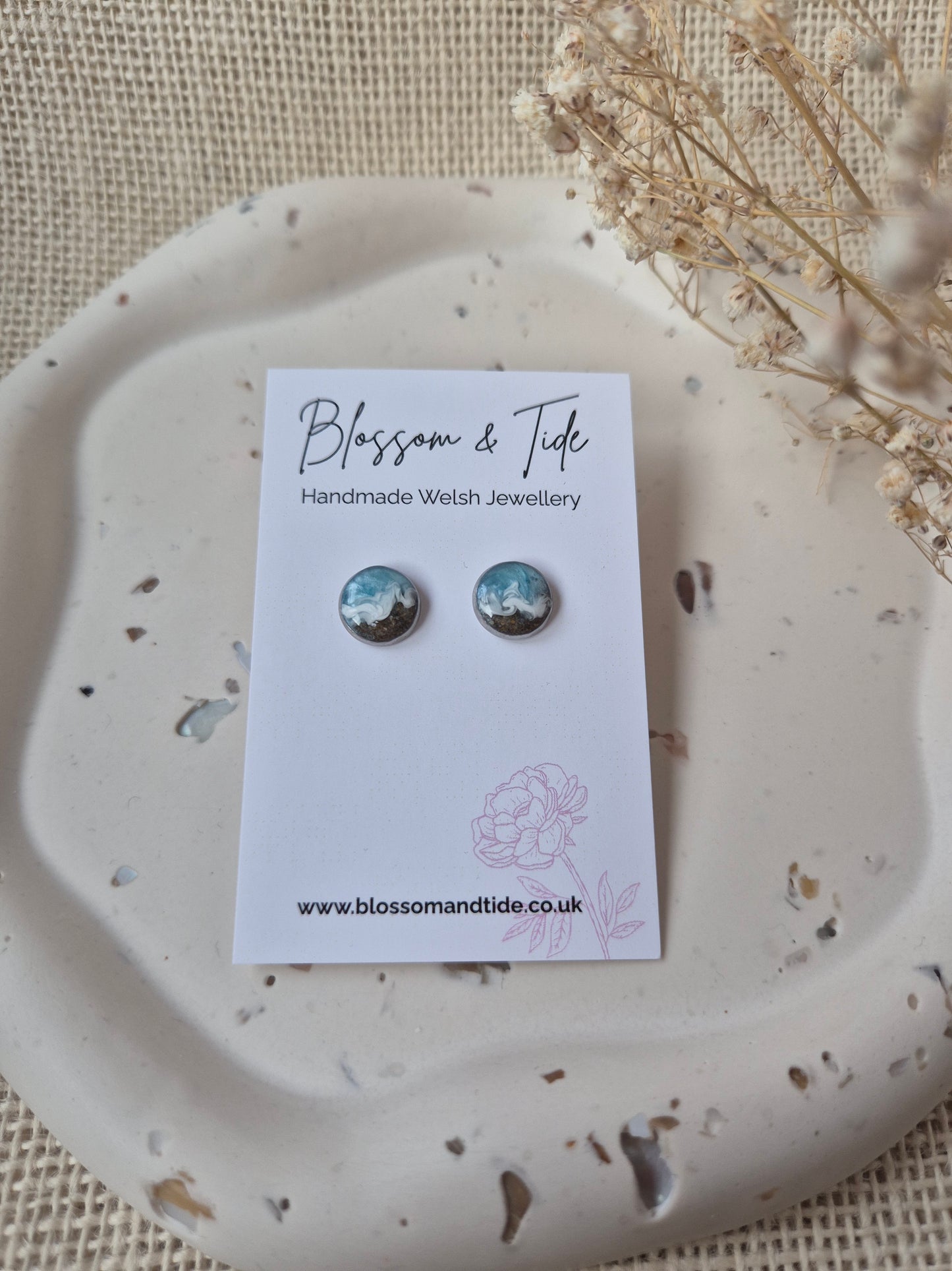 A pair of welsh beach sand earrings shown on blossom & tide branded earring card.