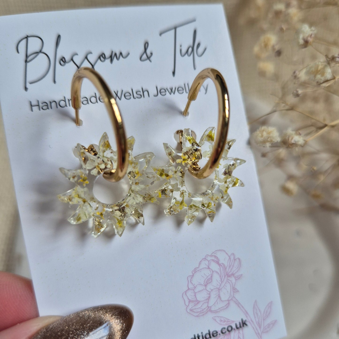 Sun earrings filled with a mix of yellow and white pressed flowers on a stainless steel gold hoop. Presented on a Blossom & Tide branded card.