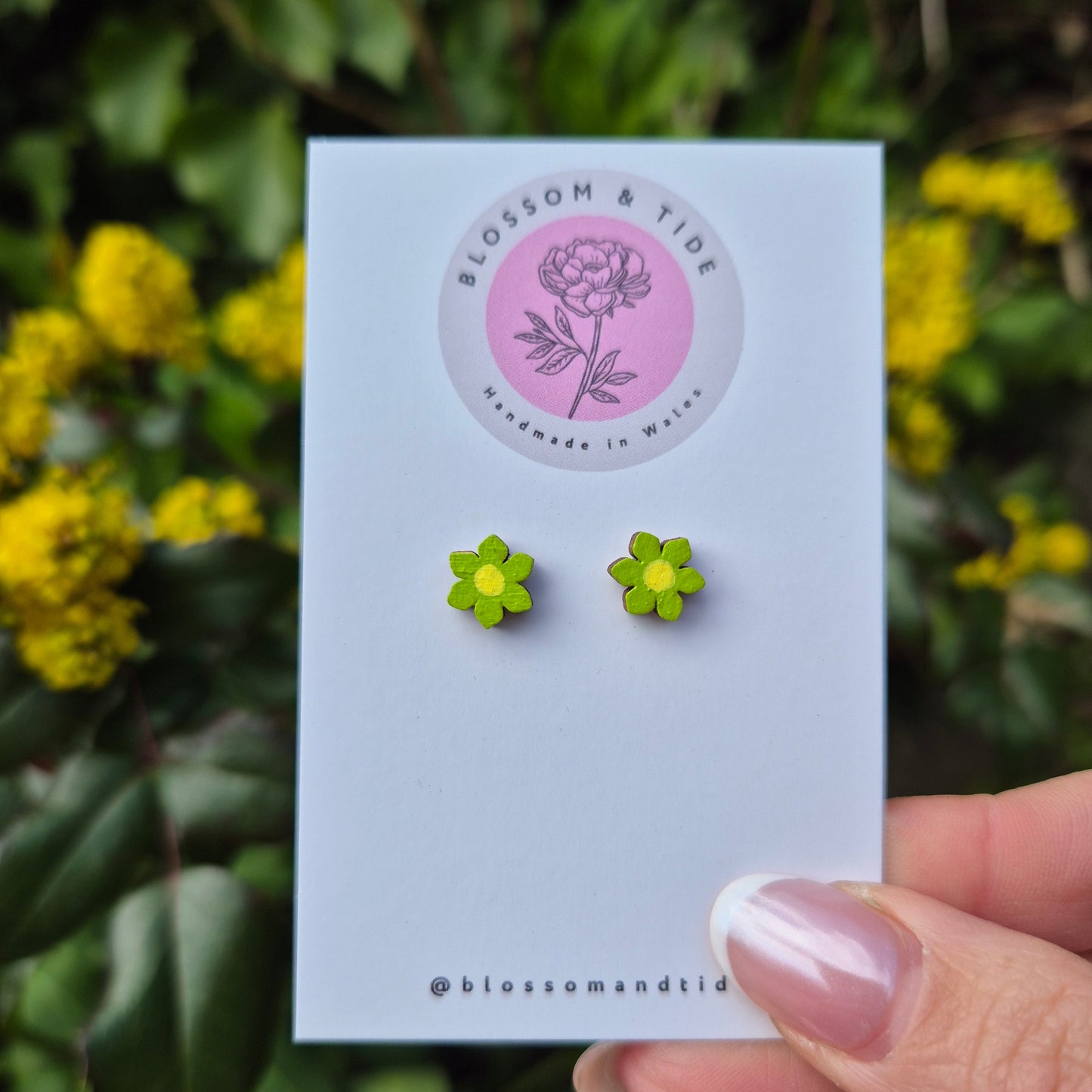 A pair of 8mm hand-painted mini flower stud earrings in a choice of colours, displayed on a branded card with an organza gift bag.