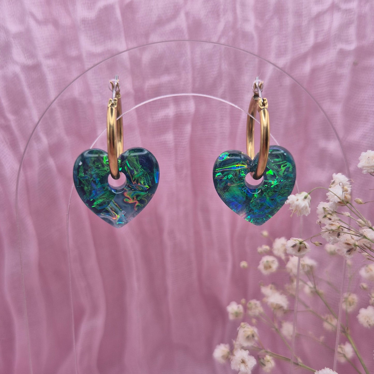 Handmade resin heart earrings with shimmering pink dichroic film.