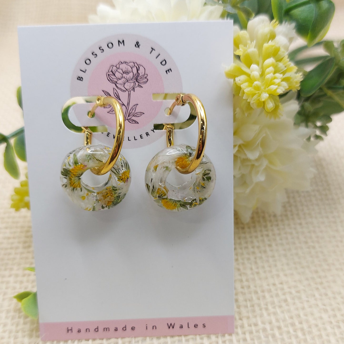 Artisan-crafted daisy hoop earrings presented on a branded card