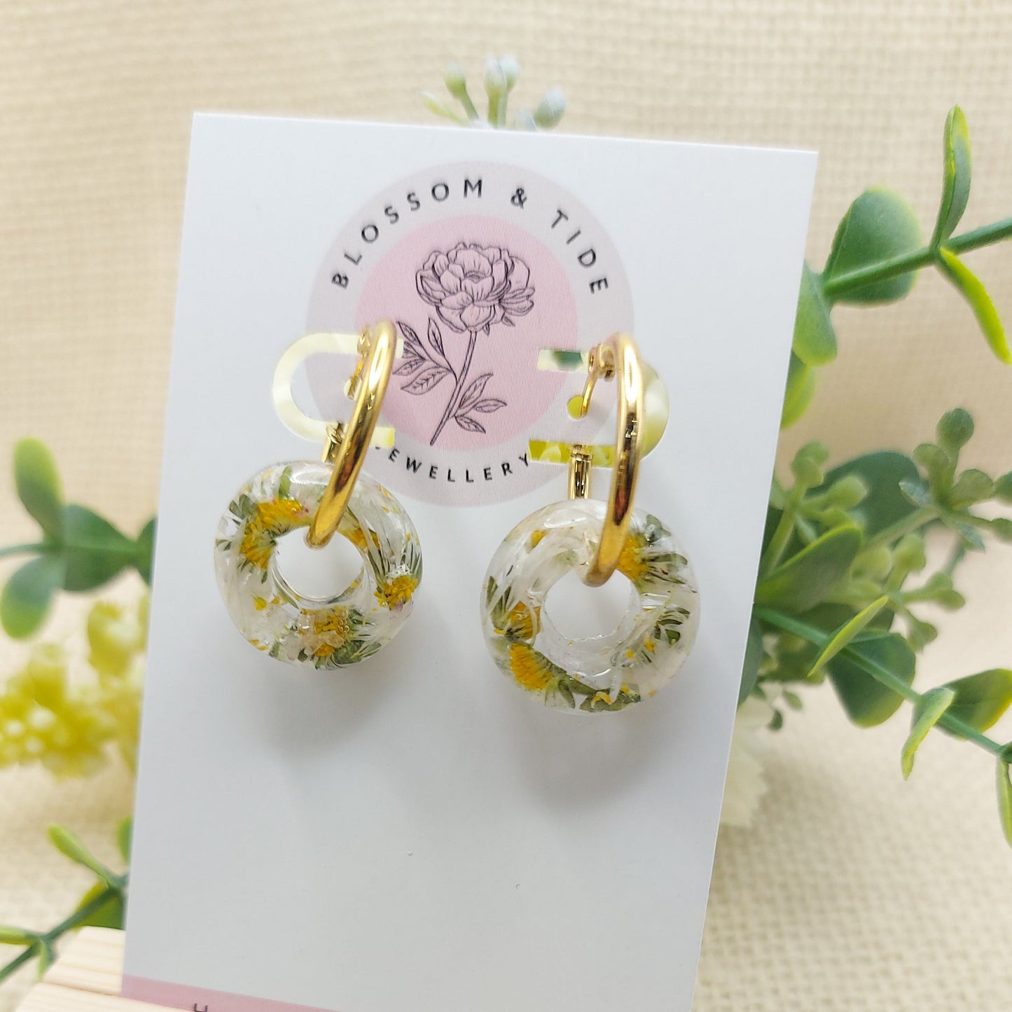 Artisan-crafted daisy hoop earrings presented on a branded card.