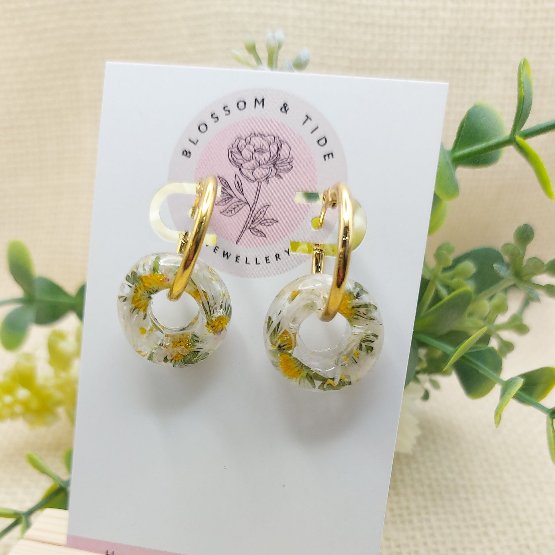 Artisan-crafted daisy hoop earrings presented on a branded card.