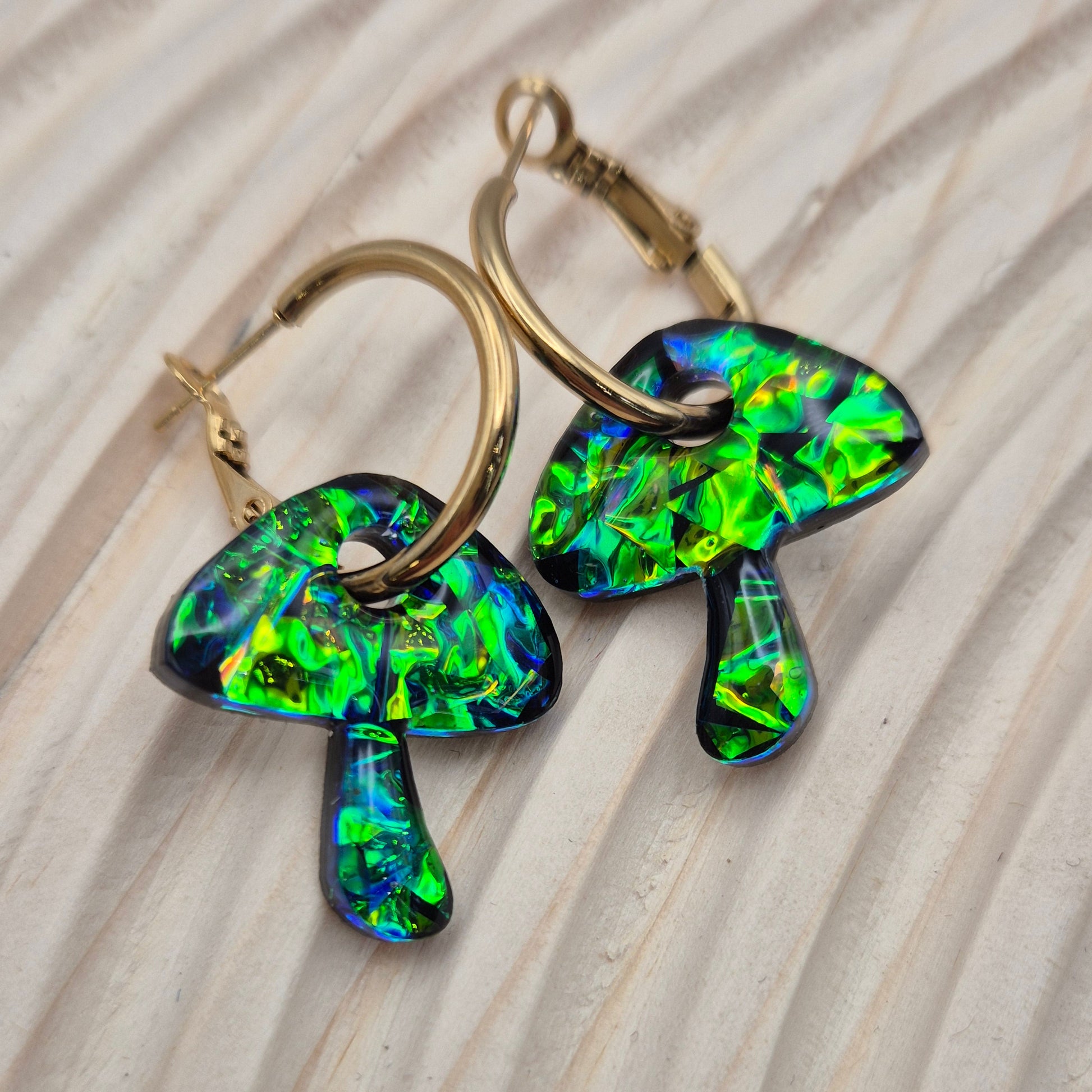 Magical handcrafted mushroom hoop earrings presented on a branded card