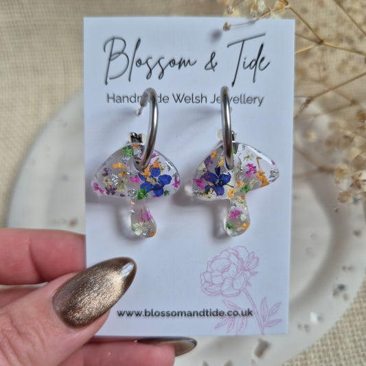 Mushroom hoops with forget-me-nots, pink and orange flowers on stainless steel silver hoops. Shown on Blossom & Tide branded card.