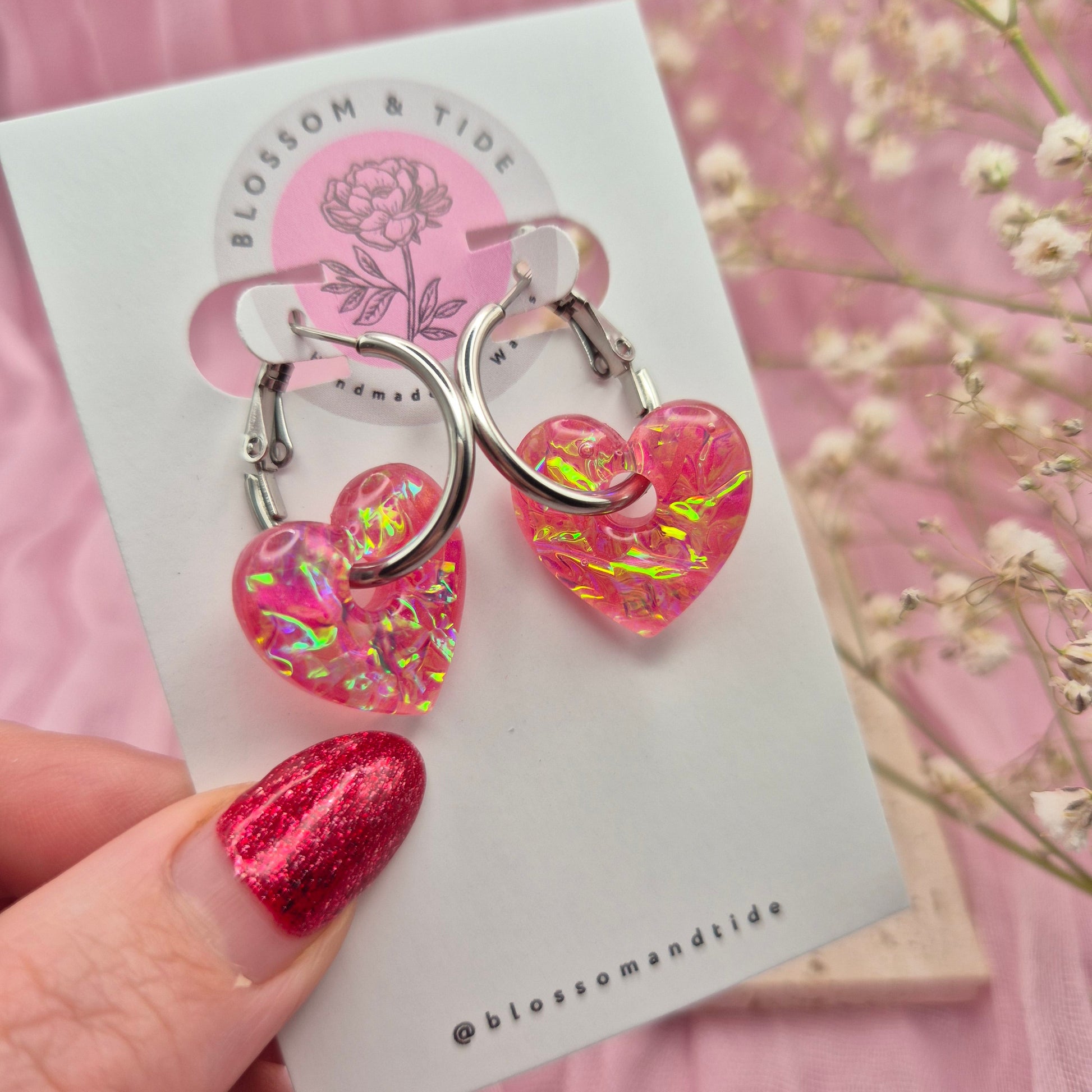 Artisan-crafted dichroic heart earrings presented on a branded card.