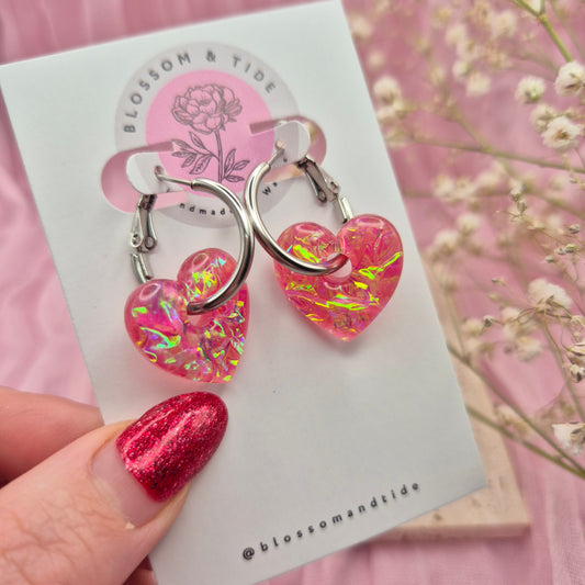 Artisan-crafted dichroic heart earrings presented on a branded card.