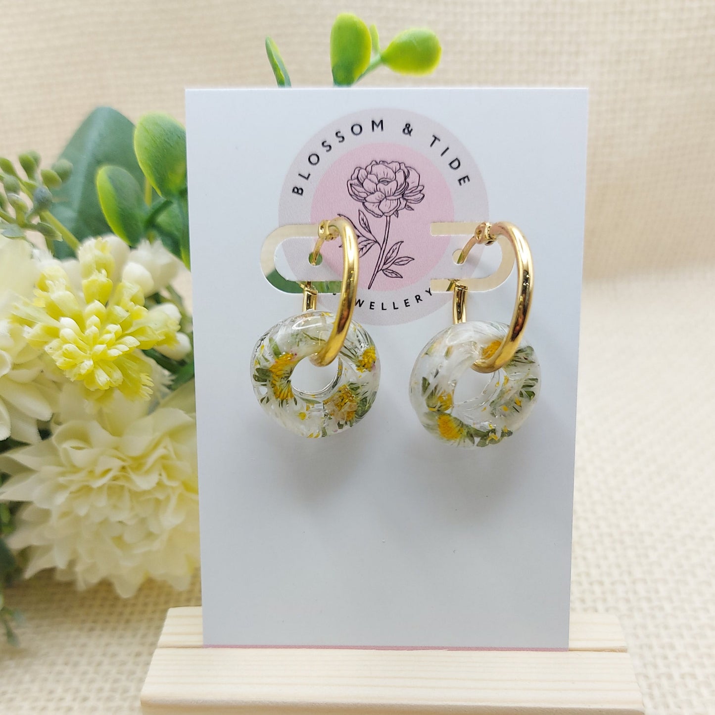 Artisan-crafted daisy hoop earrings presented on a branded card.