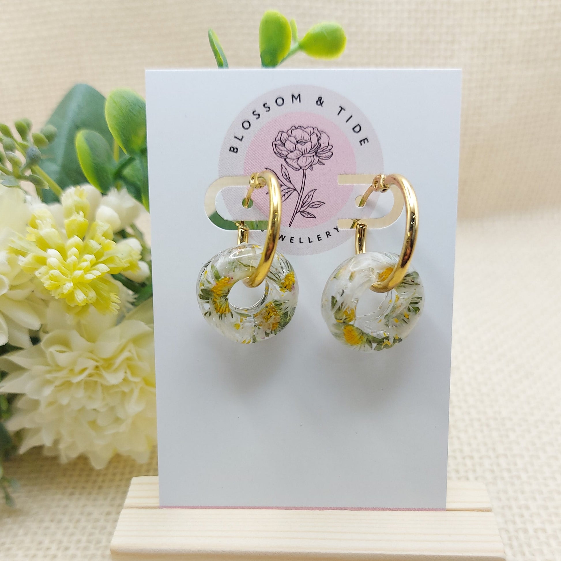 Artisan-crafted daisy hoop earrings presented on a branded card.