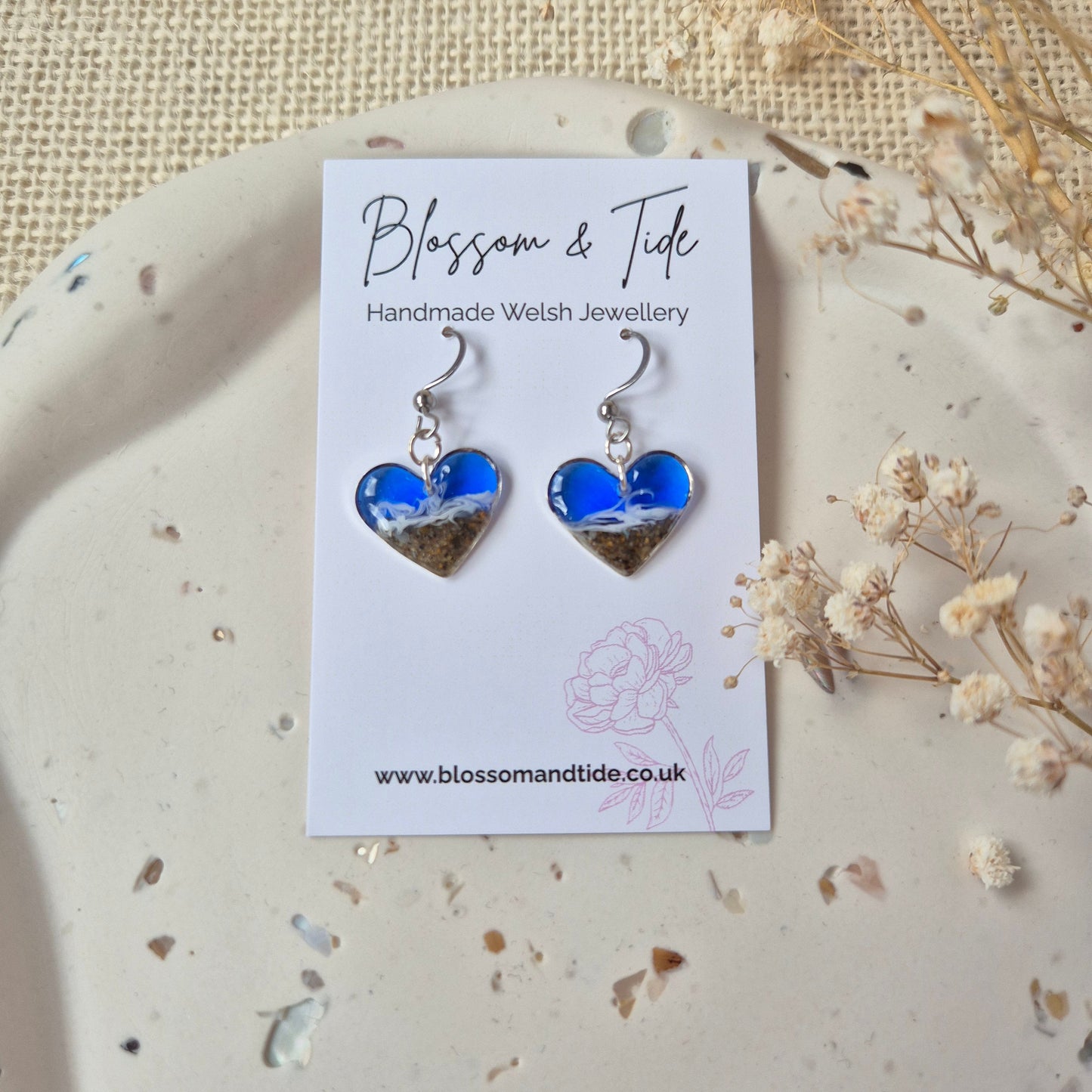 welsh beach sand heart shaped earrings on a branded "blossom & Tide" card, against a neutral background