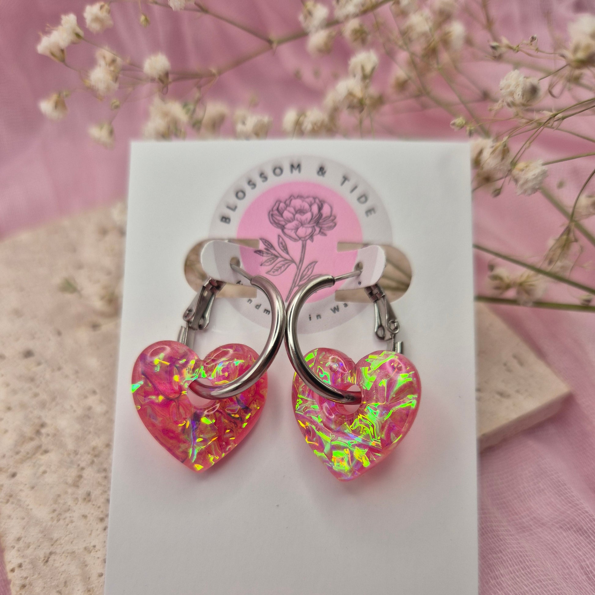 Artisan-crafted dichroic heart earrings presented on a branded card.