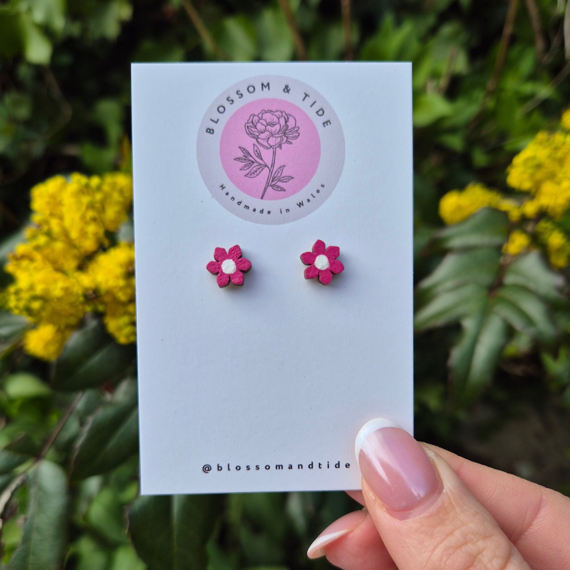 A pair of 8mm hand-painted mini flower stud earrings in a choice of colours, displayed on a branded card with an organza gift bag.