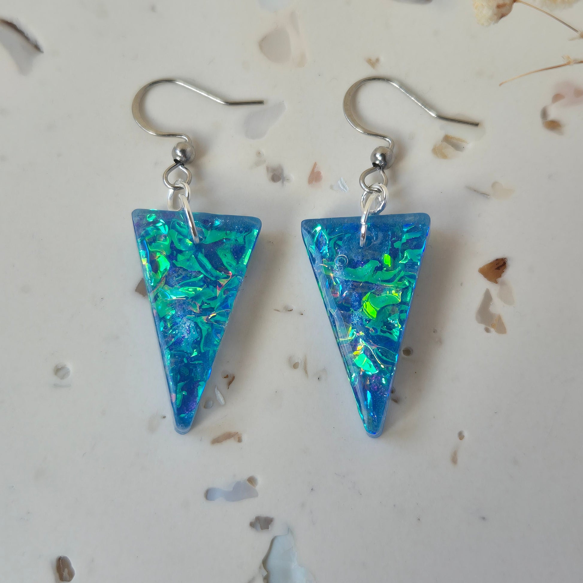 Blue triangle-shaped earrings on a light background