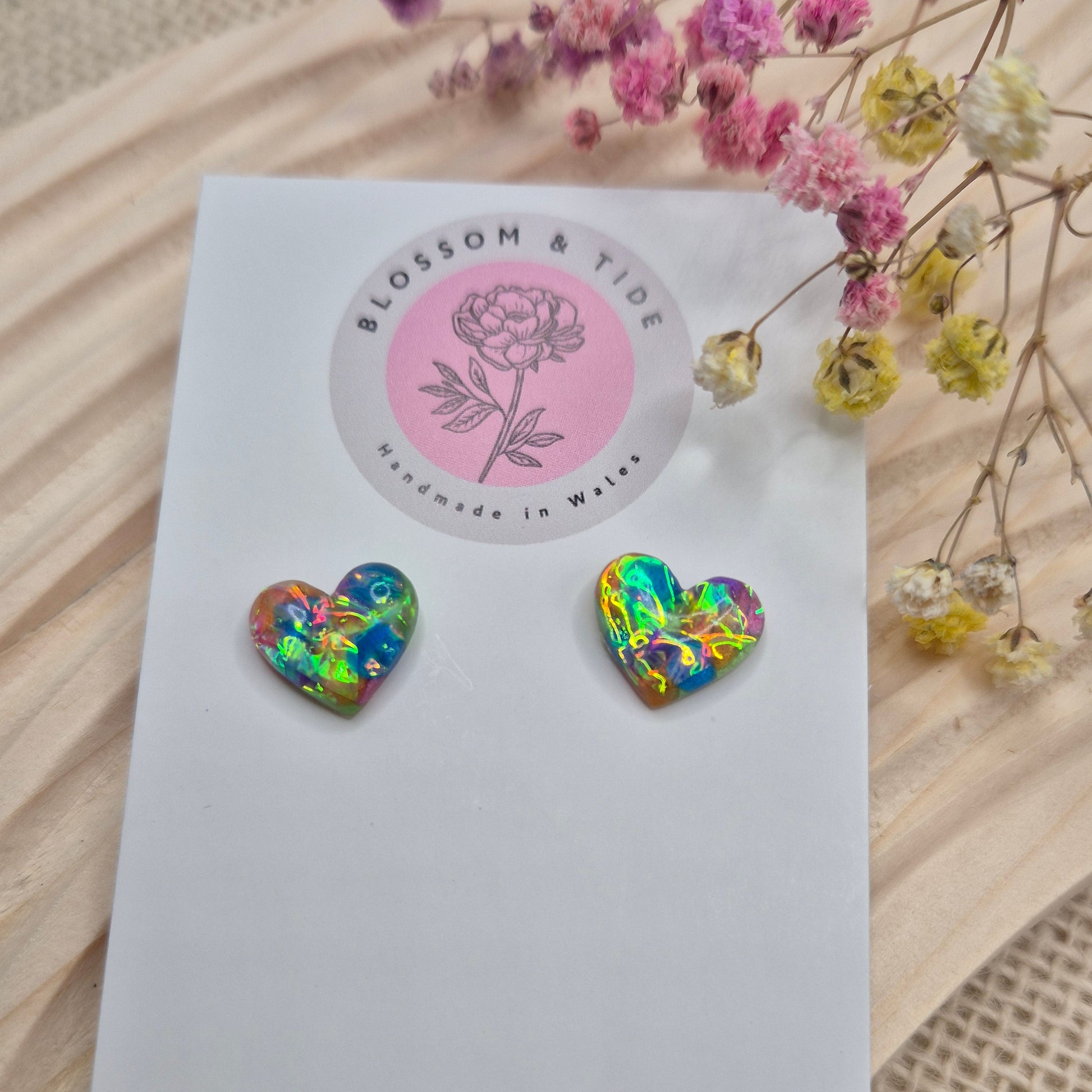 Heart-shaped stud earrings on branded display card, presented in an organza gift bag
