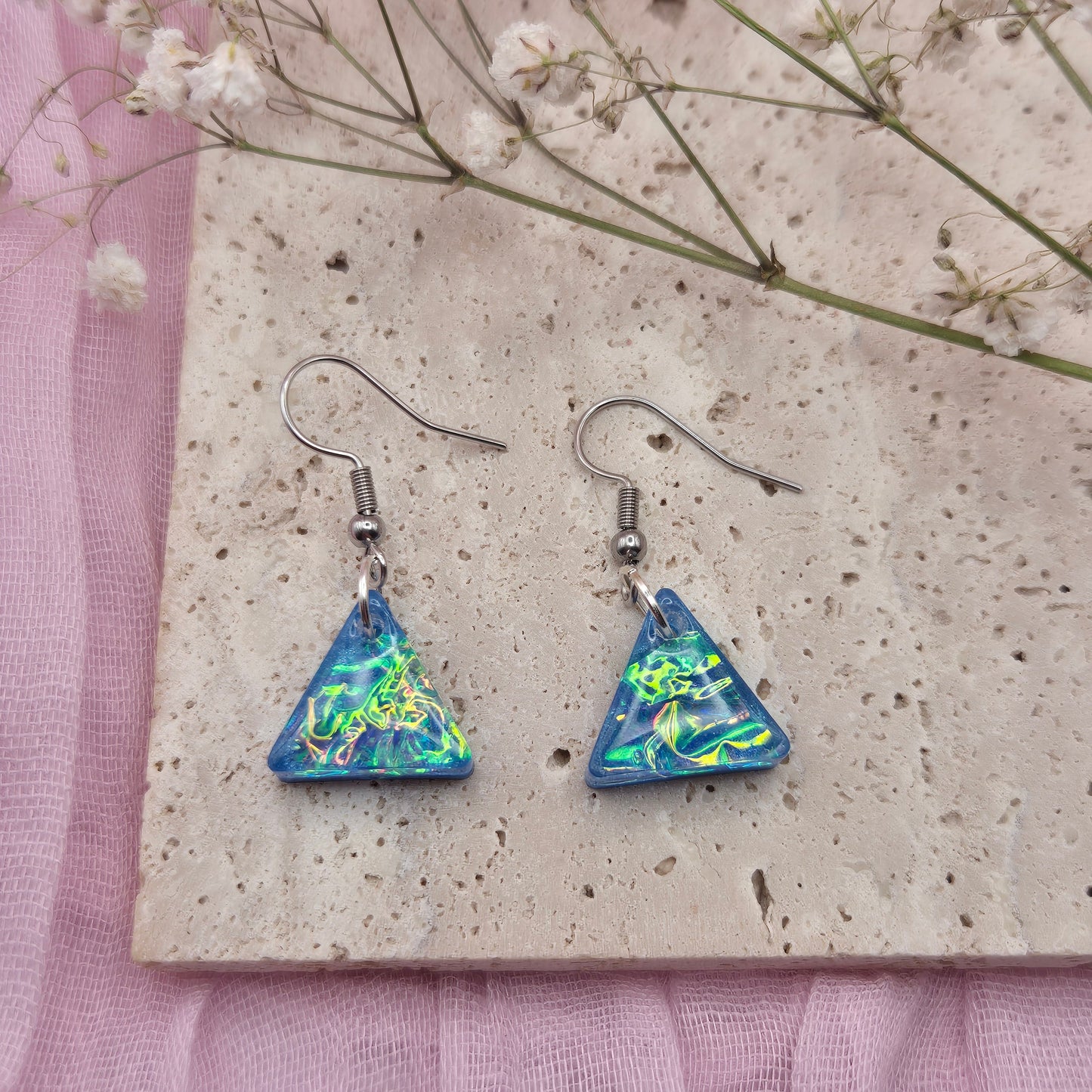 Triangle-shaped statement earrings reflecting colourful light, handmade in Wales