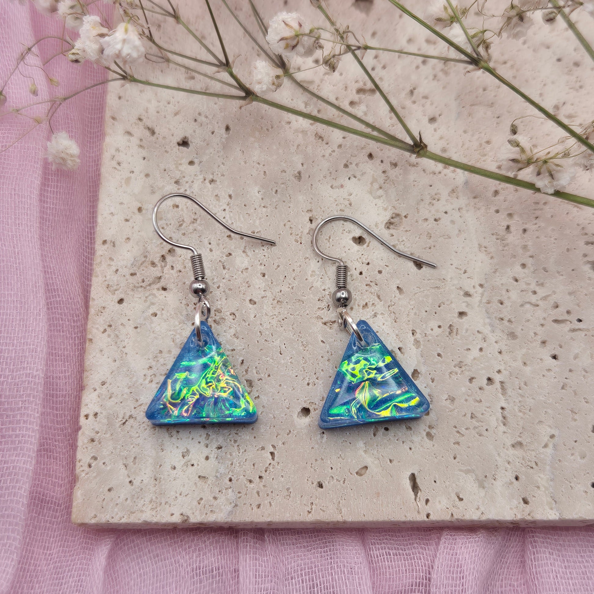 Triangle-shaped statement earrings reflecting colourful light, handmade in Wales