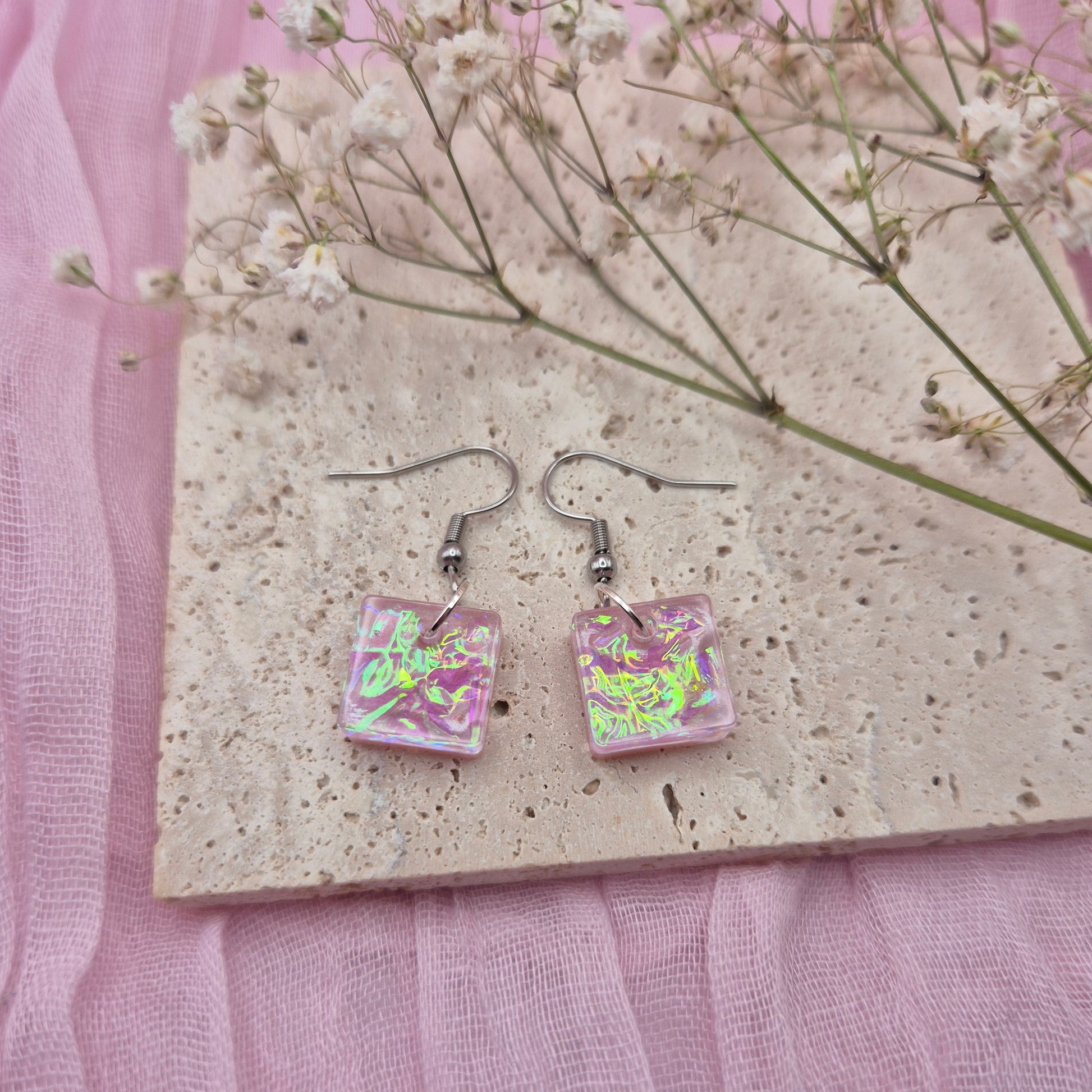 Triangle-shaped statement earrings reflecting colourful light, handmade in Wales