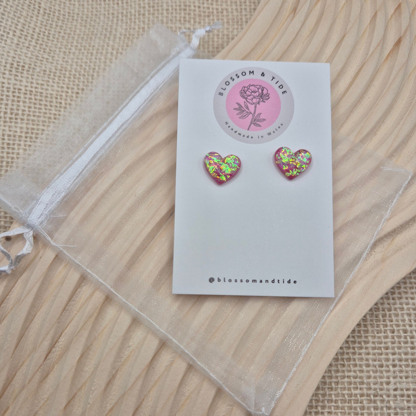 Heart-shaped stud earrings on branded display card, presented in an organza gift bag