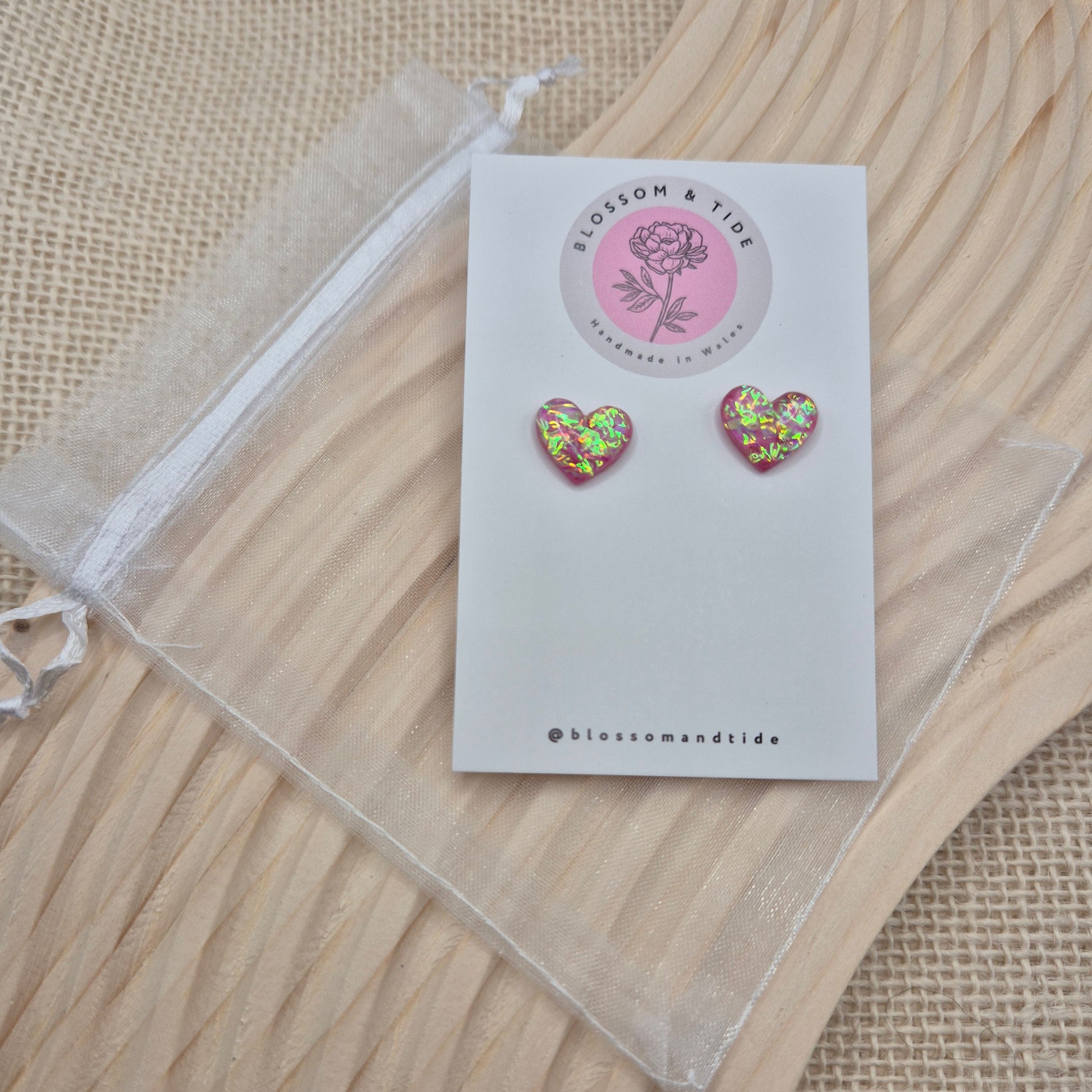 Heart-shaped stud earrings on branded display card, presented in an organza gift bag