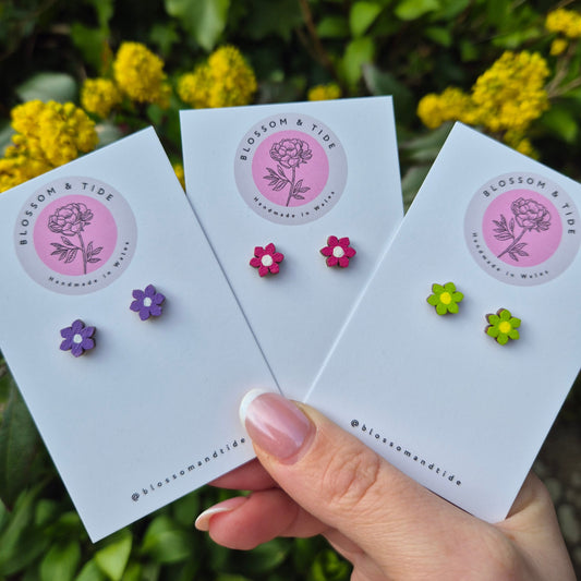 A pair of 8mm hand-painted mini flower stud earrings in a choice of colours, displayed on a branded card with an organza gift bag.