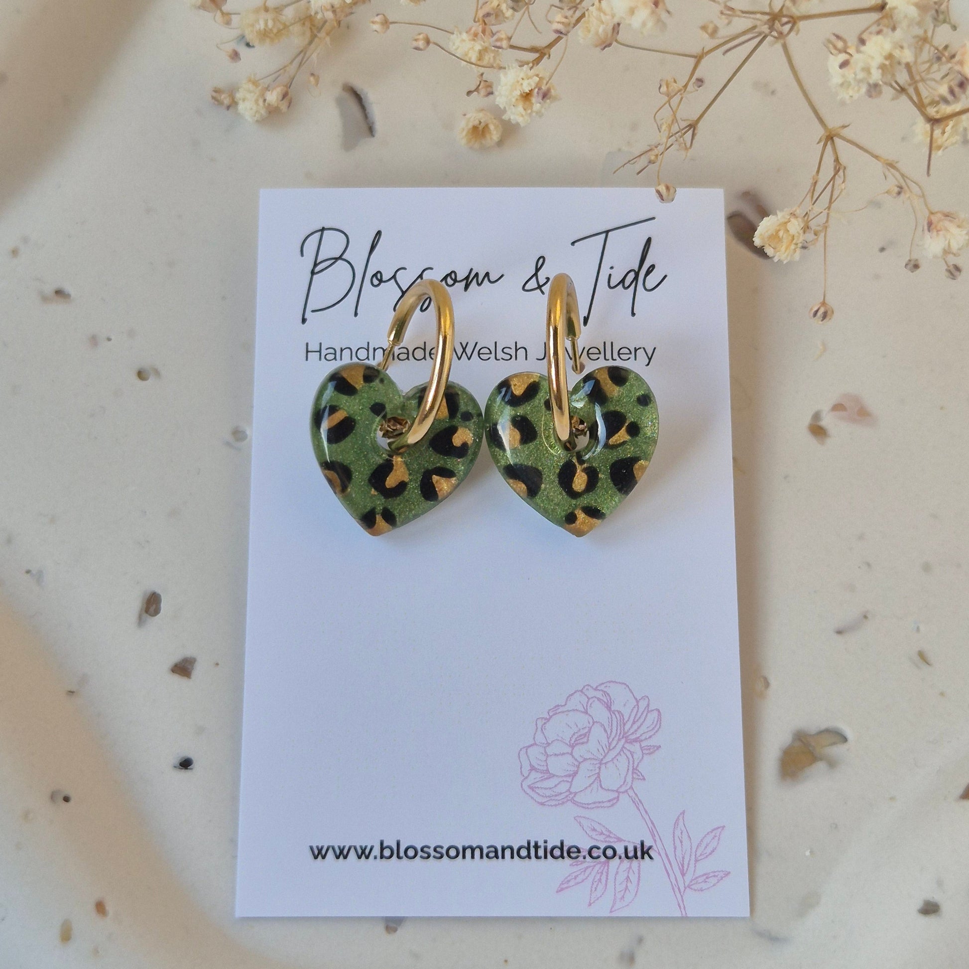 Olive green leopard print heart earrings on gold hoop on a branded 'blossom and tide card' against a neutral background