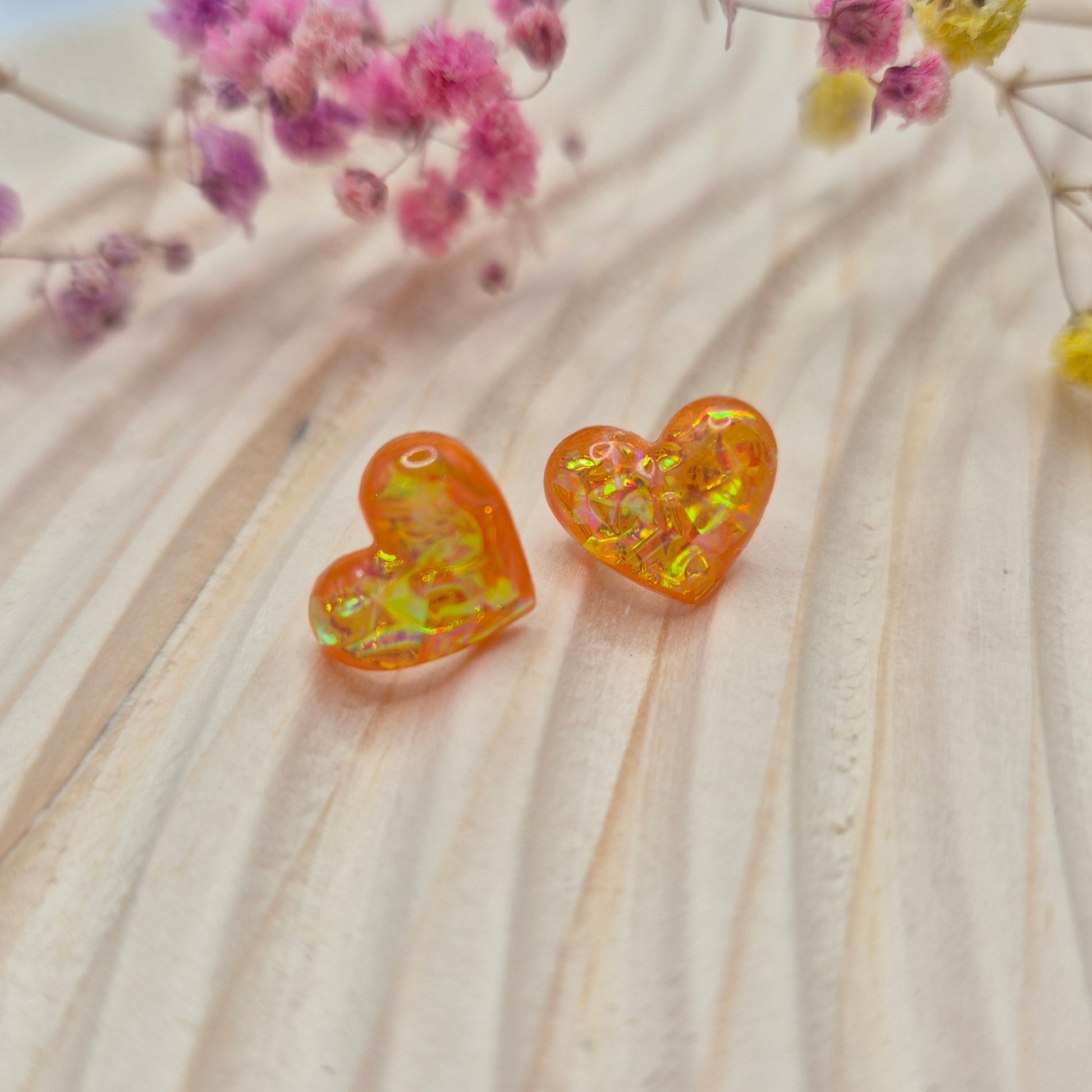Holographic resin earrings catching the light, ideal for romantic or everyday wear