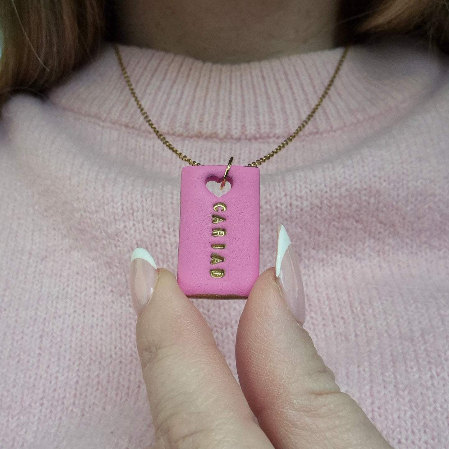 Handmade pink Cariad necklace with hand-painted gold details on a gold stainless steel chain
