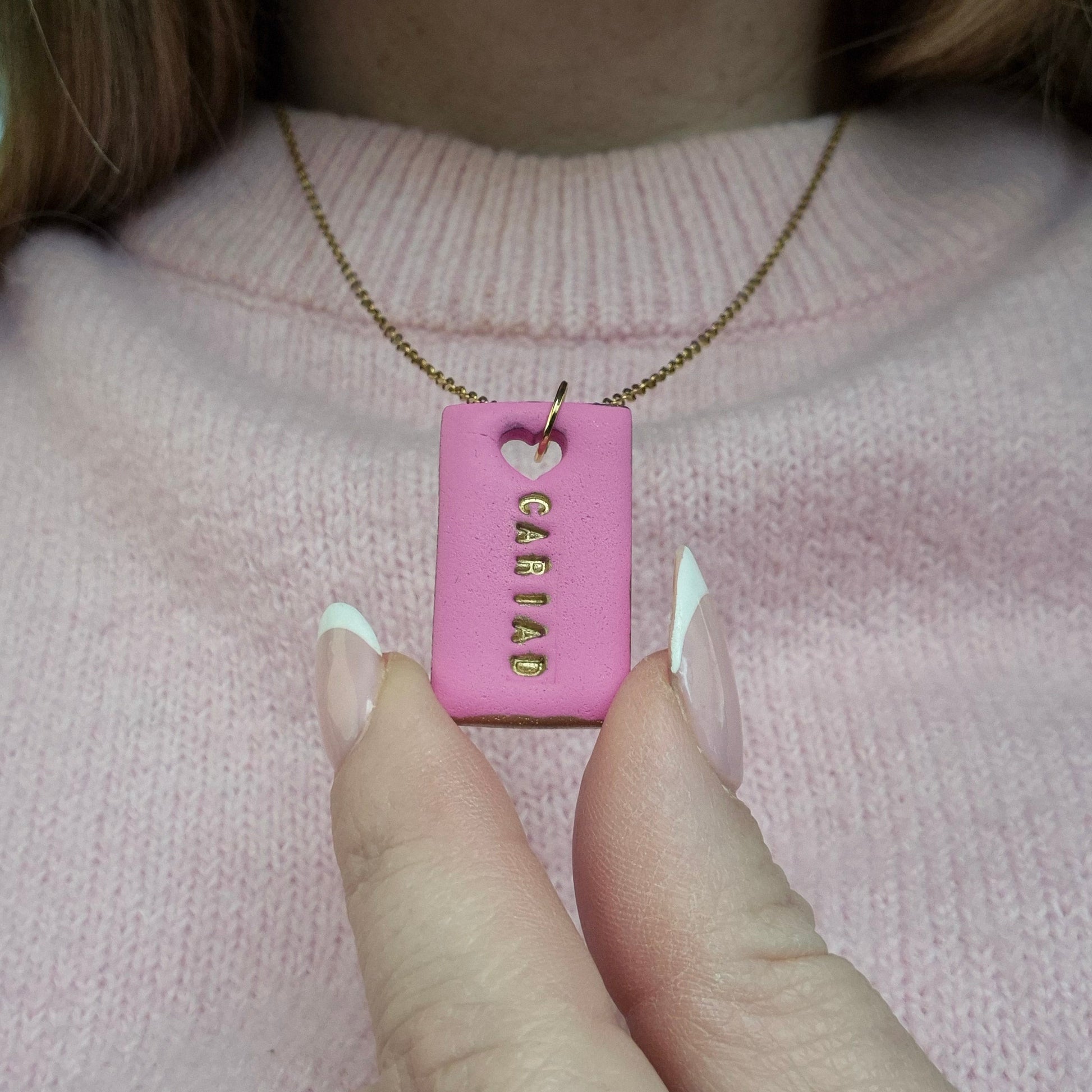 Handmade pink Cariad necklace with hand-painted gold details on a gold stainless steel chain