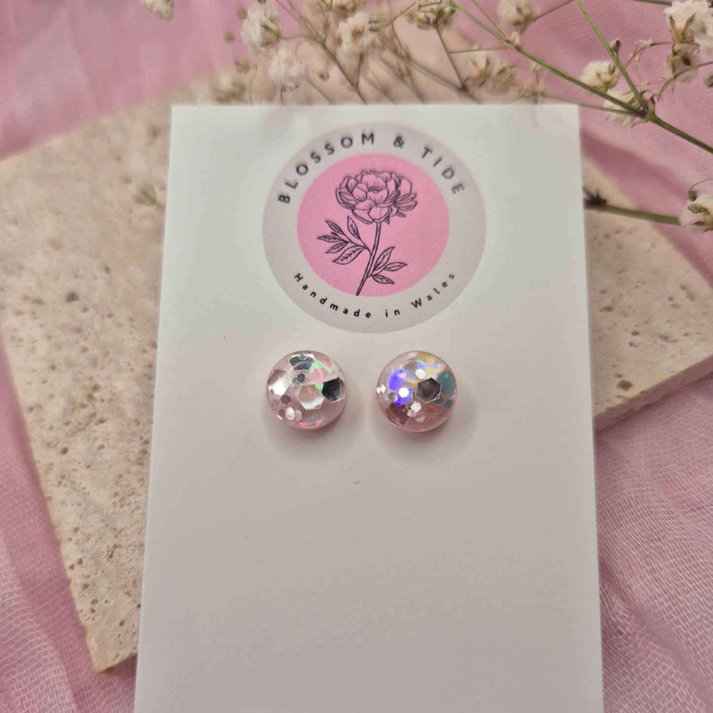 Round resin earrings featuring a delicate pink background and shimmering glitter accents