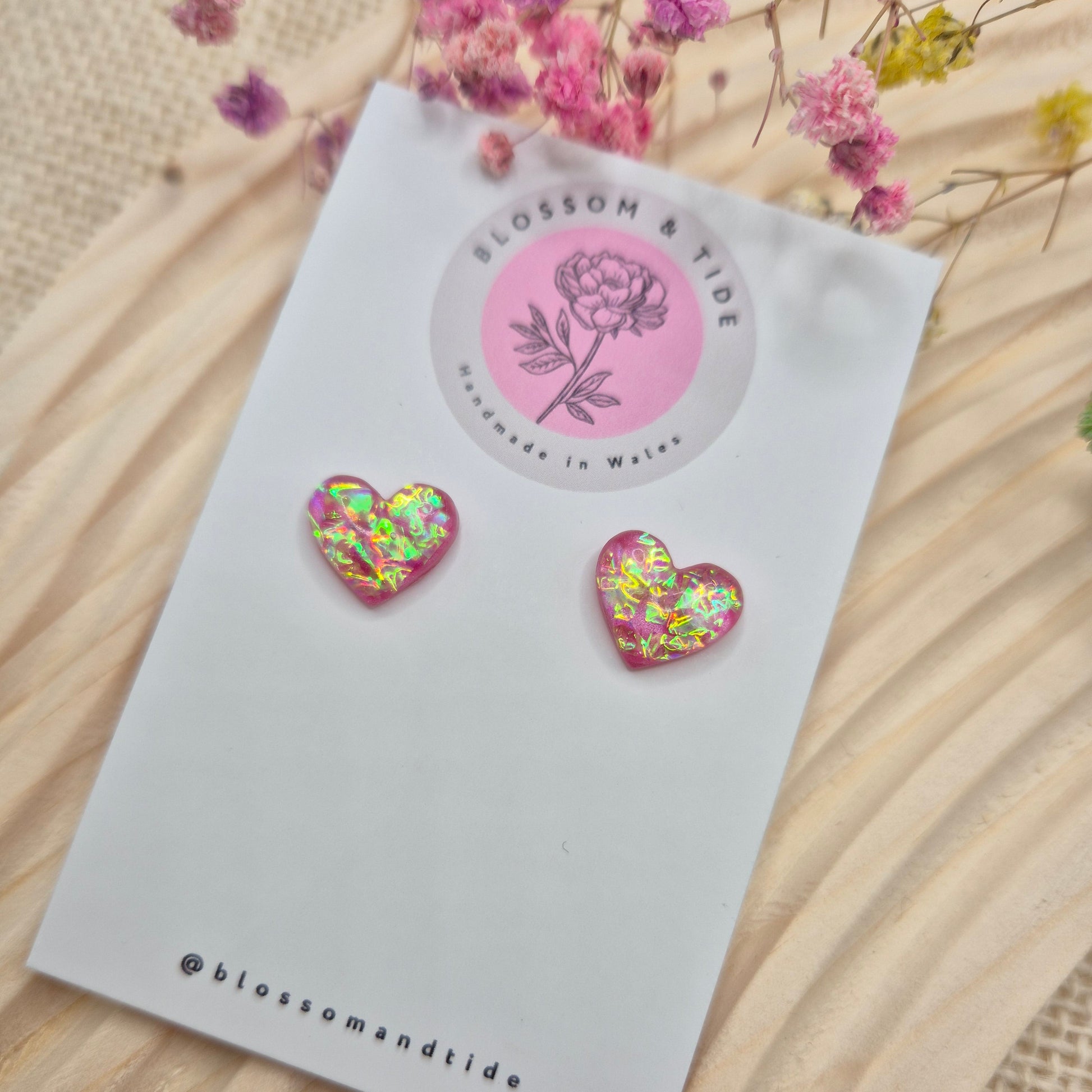 Heart-shaped stud earrings on branded display card, presented in an organza gift bag