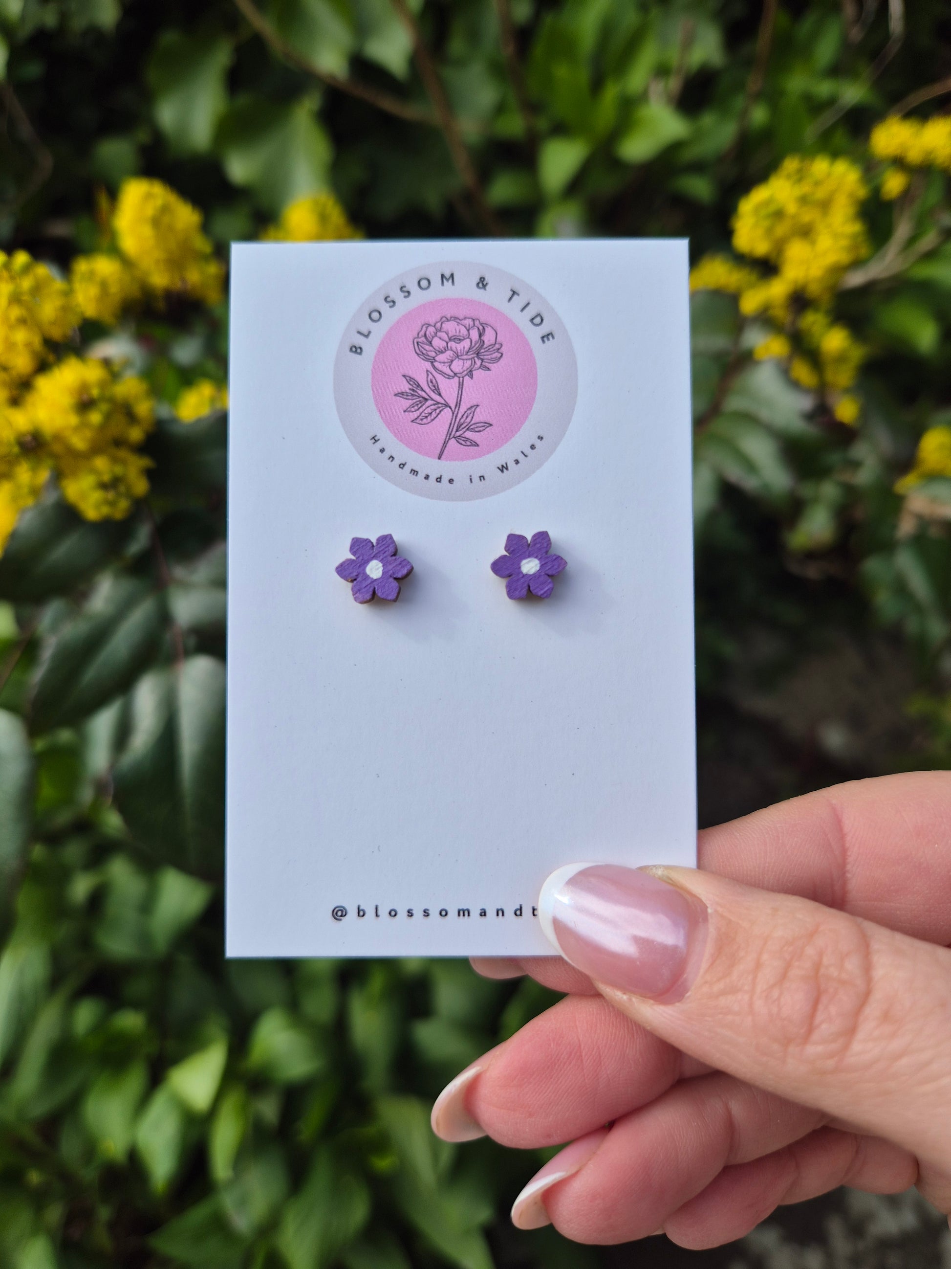 A pair of 8mm hand-painted mini flower stud earrings in a choice of colours, displayed on a branded card with an organza gift bag.