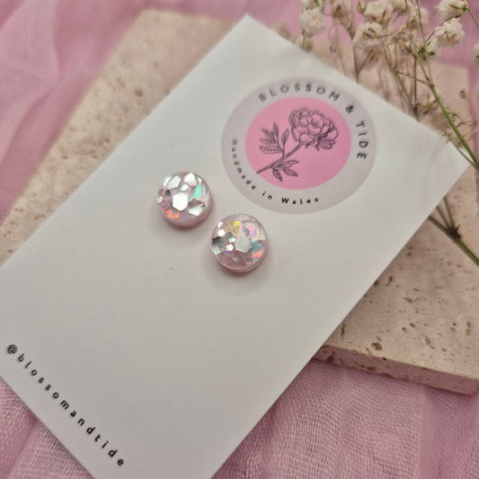 Round resin earrings featuring a delicate pink background and shimmering glitter accents